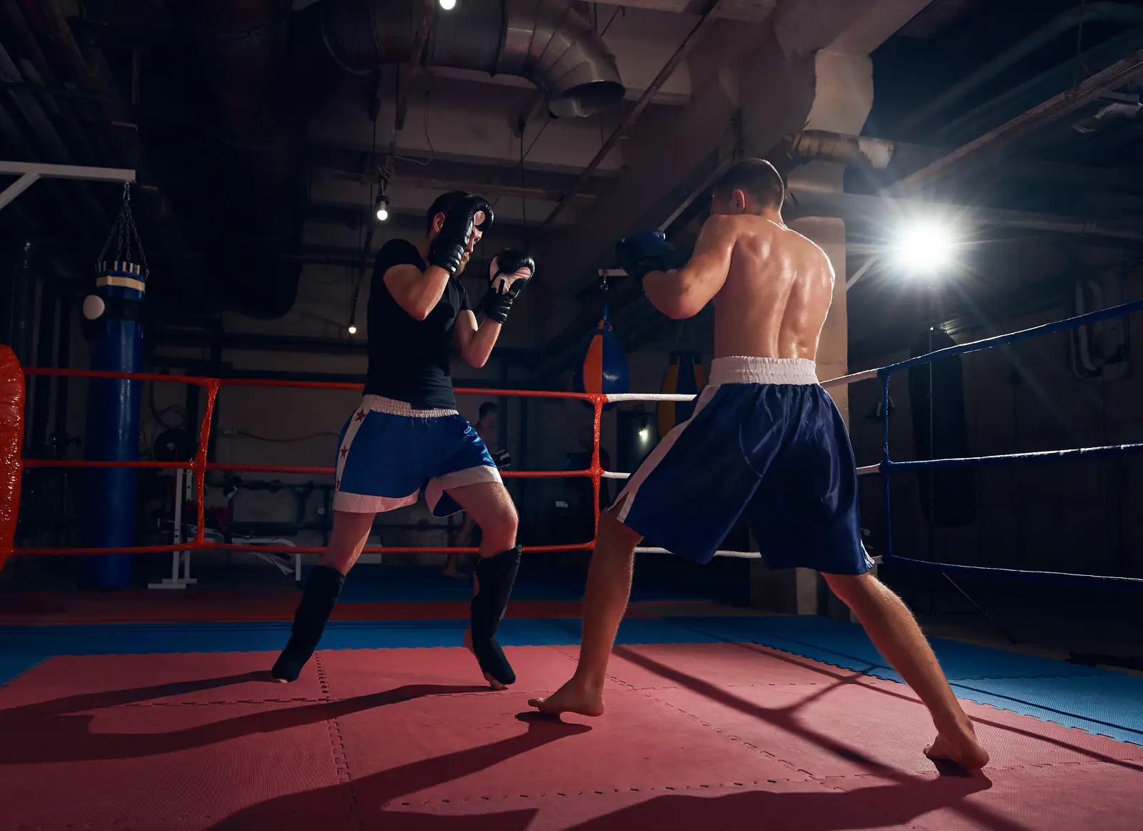 Two boxers sparring in a ring under the lights at night