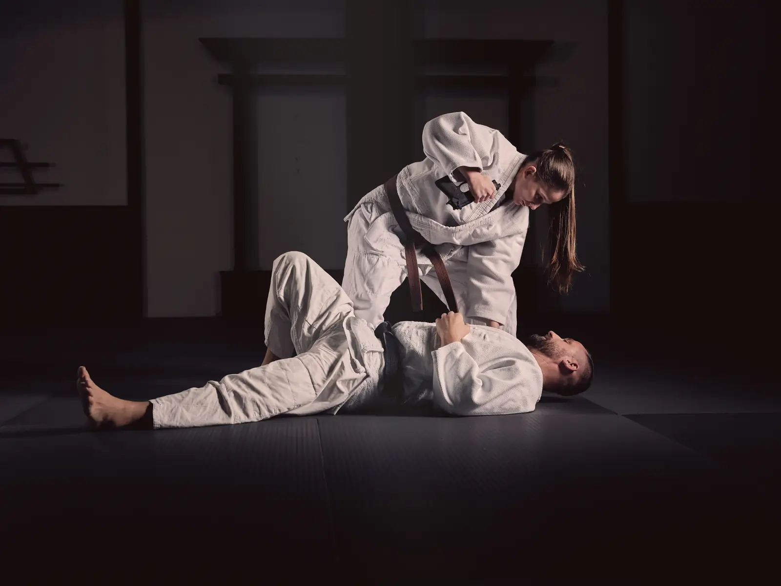Two jiu-jitsu practitioners drilling a technique on the mat