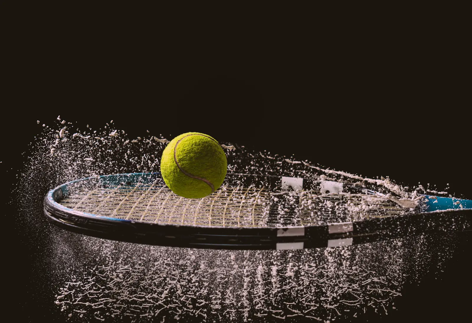 Tennis ball striking the strings of a racquet