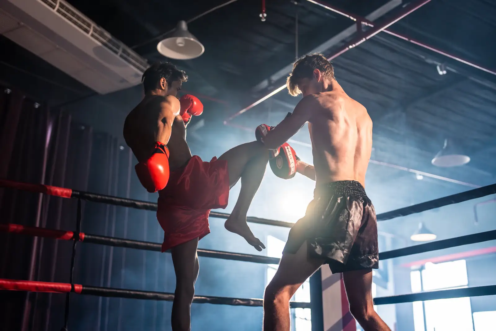 Two young Muay Thai fighters sparring in a ring